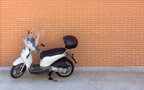 砖墙的白色小型摩托车