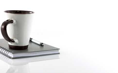 杯咖啡和笔记本隔离在白色背景上