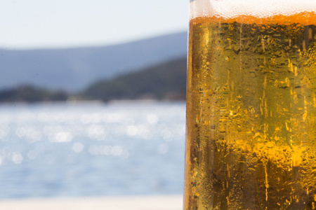 海滩桌上一品脱冰镇啤酒图片