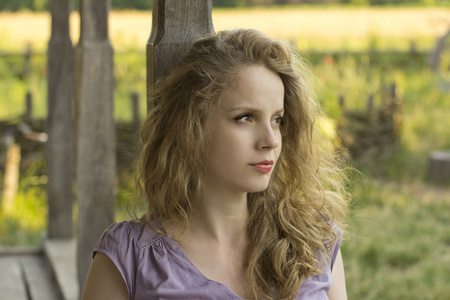 beautiful 卷曲的金发女郎享受农村阳光.在头发中的曙光.乡村风格.