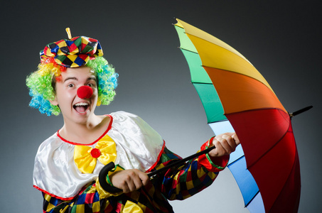 用五颜六色的伞的滑稽小丑图片