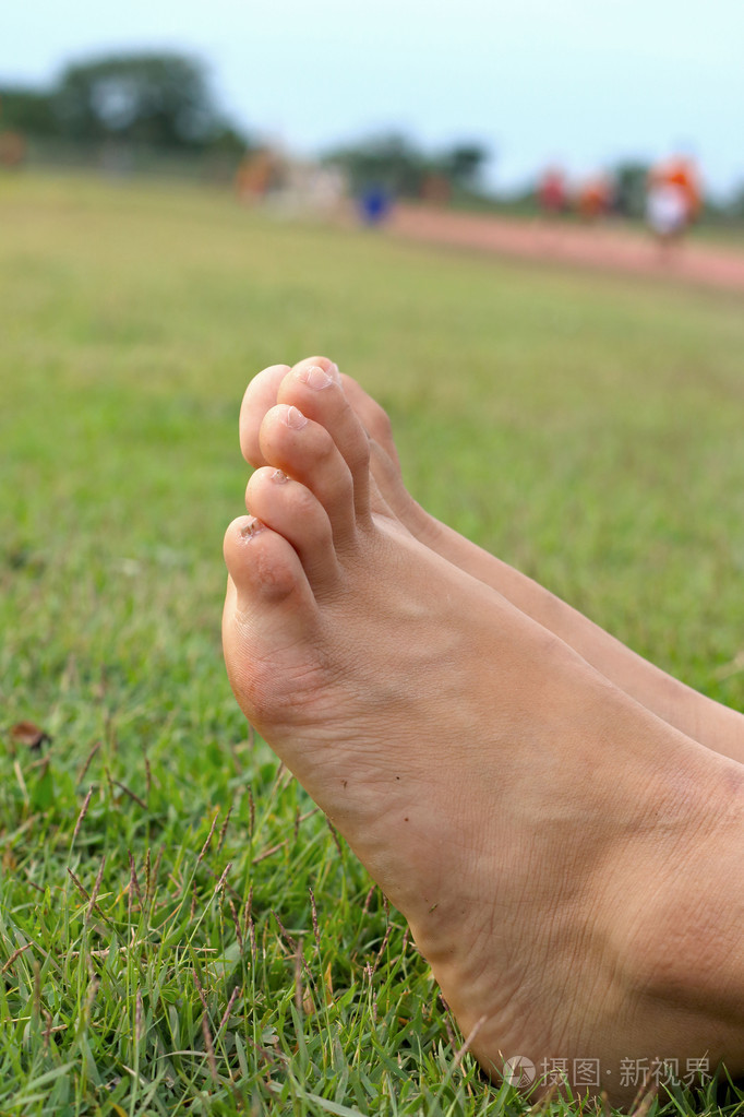 赤脚在绿色的草坪上