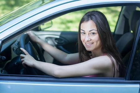 幸福的年轻女人，驾驶一辆车