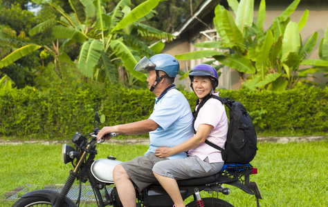 亚洲的年长夫妇驾驶摩托车旅行