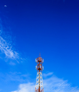 电信塔在下午明亮的阳光和多云的蓝色
