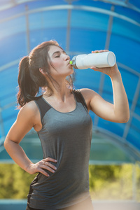 出汗锻炼的女人喝水