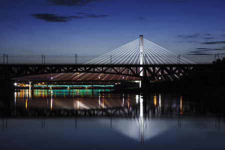 在晚上，倒映在水突出显示的桥