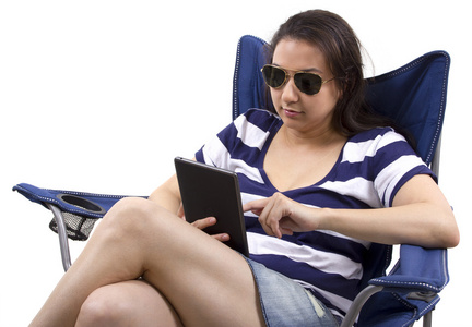 女性在沙滩椅上的平板电脑