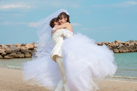 年轻 漂亮的新娘和新郎在海滩上
