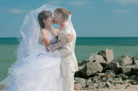 年轻 漂亮的新娘和新郎在海滩上