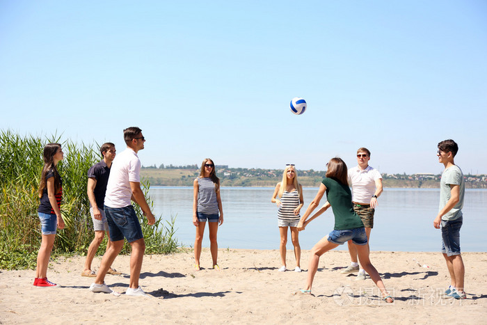 群的朋友在海滩上打排球