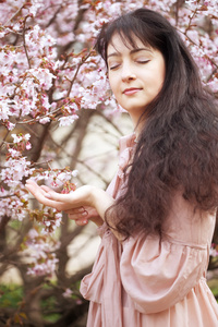 在春天花朵的花园里的女人