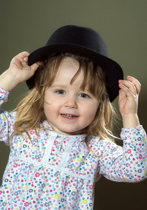 可爱的小女孩玩帽子