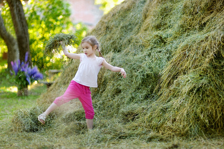 在干草堆里玩的小女孩
