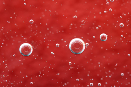 在液体中的气泡。抽象的红色背景。宏