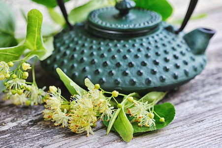 林登茶和老木背景上的花茶壶