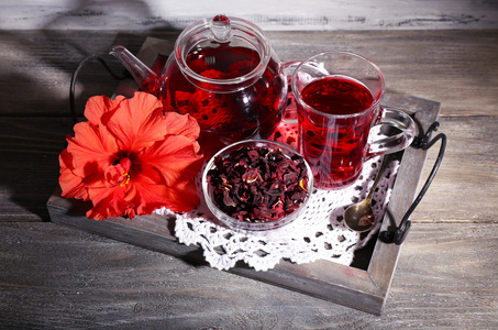 木槿花茶玻璃茶壶，木制背景颜色餐巾花