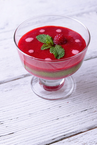 草莓 猕猴桃果实和覆盆子果汁在玻璃碗颜色木制背景上