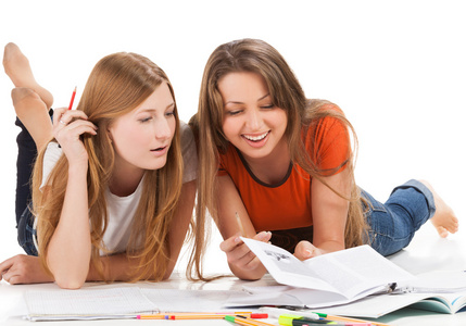 在笔记本电脑上的两个年轻的快乐学生女孩工作