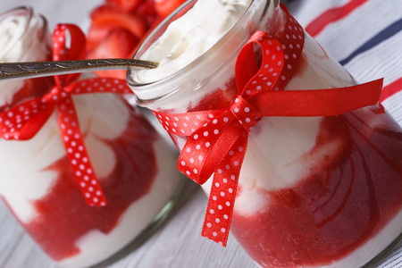 在一个罐子里用勺子水平的草莓酸奶