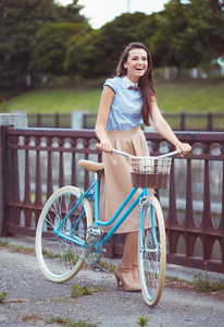 与自行车年轻美丽 衣着优雅的女子