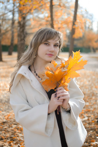 秋天的叶子的年轻女人