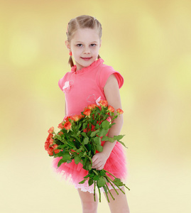 可爱的小女孩穿着粉红色的连衣裙和一束玫瑰花
