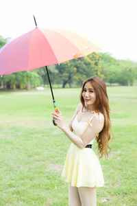 伞站在草坪上的女人