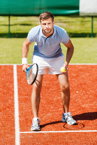 男人拥着网球拍并看集中