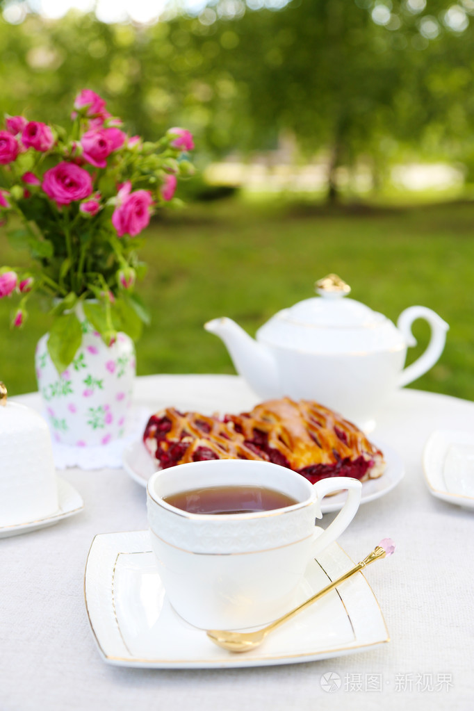 咖啡桌上的茶杯和美味的馅饼，在花园里