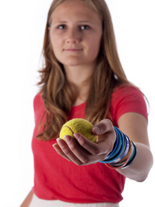 年轻的少女拿着网球专注于球
