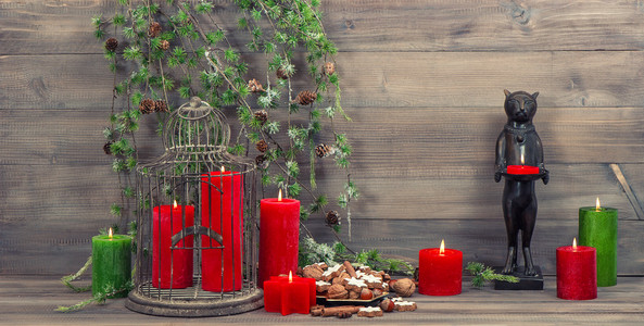 插着红蜡烛的圣诞装饰鸟笼和松树的分支