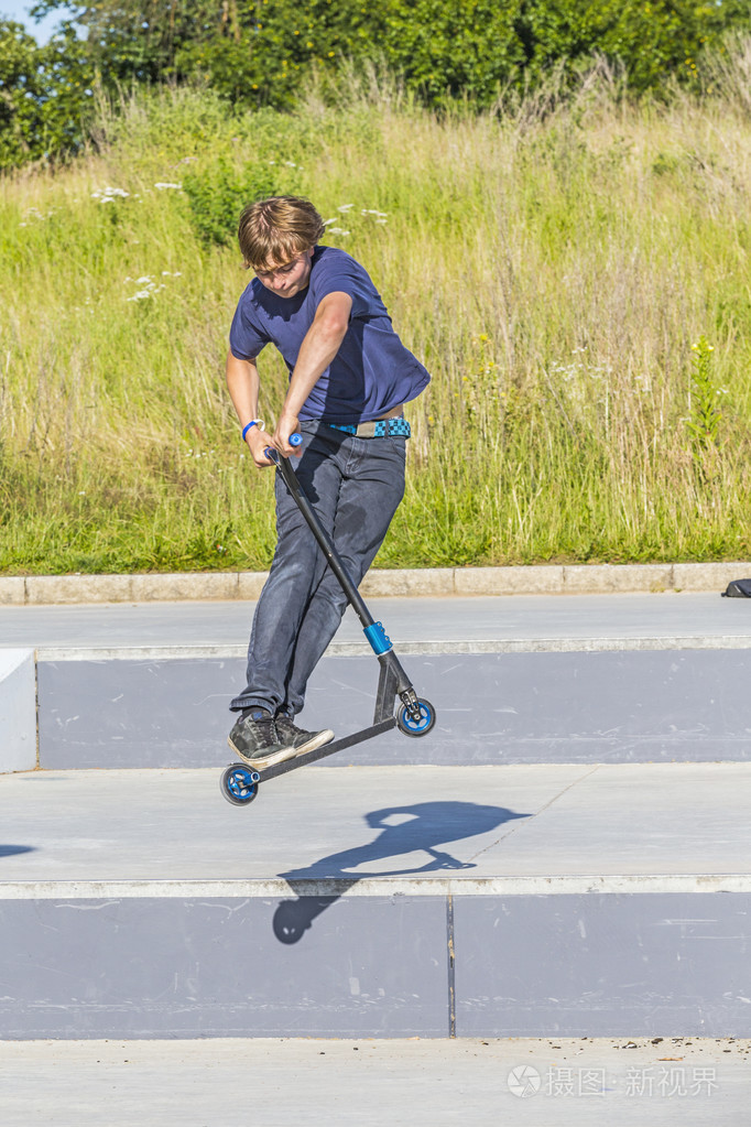 男孩有骑他推滑板车的乐趣