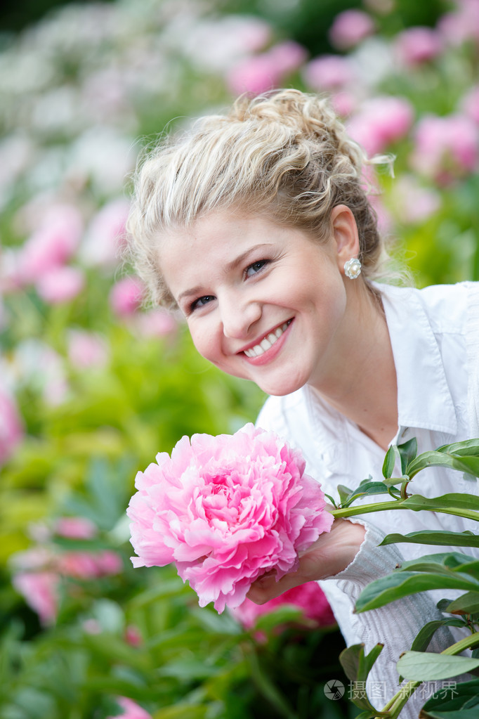 在花卉园微笑美丽幸福的女人