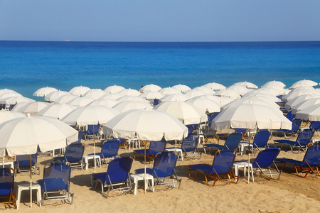 沙滩的白色遮阳伞和日光浴浴床 kathisma 莱夫卡达