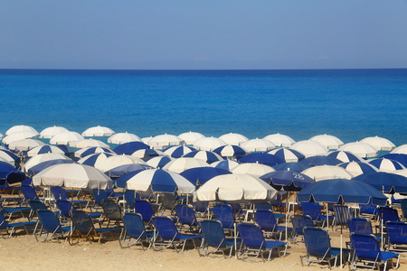 沙滩的白色遮阳伞和日光浴浴床 kathisma 莱夫卡达