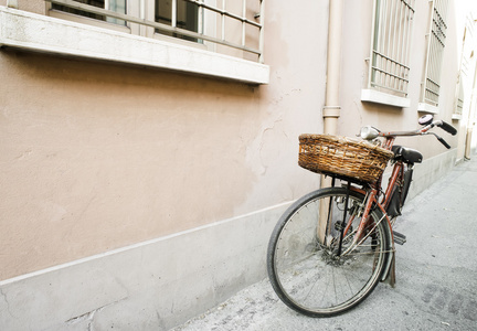 阳光下的红色旧意大利自行车。 古建筑