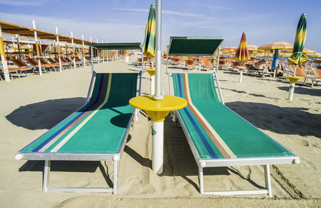 日光浴床和海滩上的遮阳伞图片