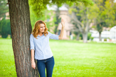 美丽的年轻女子站在一棵树