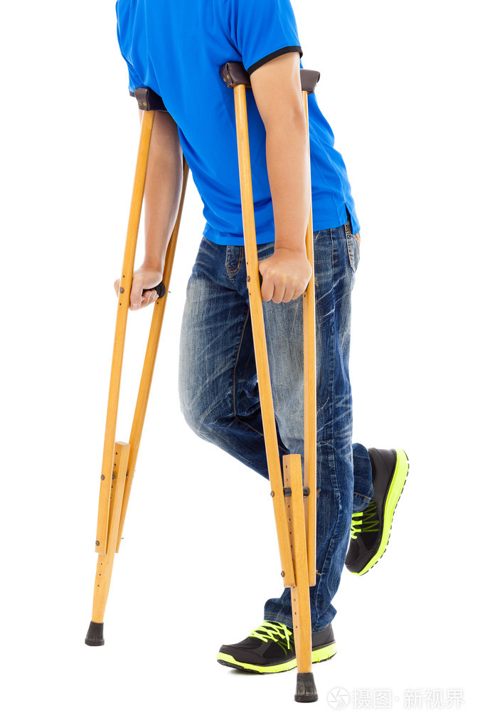 年轻男子拄着拐杖的特写白色背景