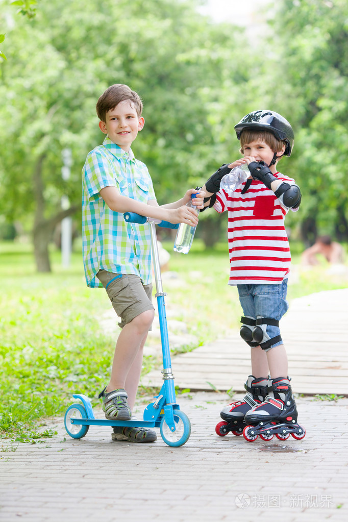 两个男孩与滑板车和辊