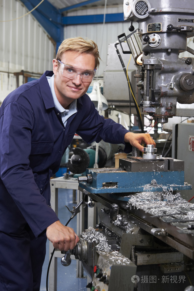 工程师在工厂中使用钻的肖像