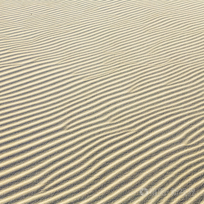 在海滩的沙波纹的背景