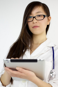 使用平板电脑的年轻亚洲女医生