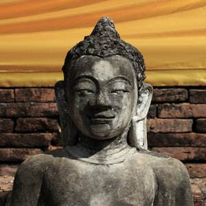 佛雕像雕刻石头与金色的脸庞图片