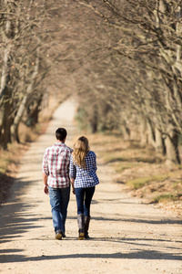 pareja joven caminando por carretera走在乡间小路上的年轻夫妇