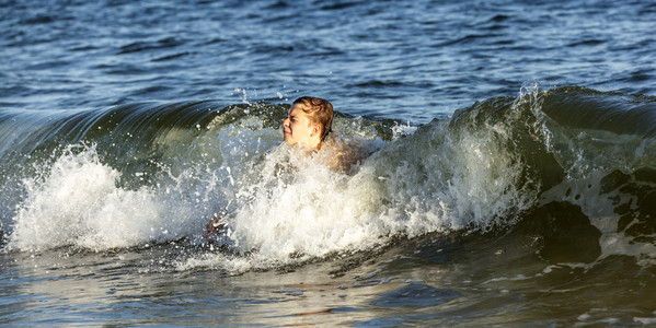 男孩喜欢在波浪里游泳