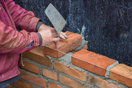 建筑工人用抹子铺实心粘土砖