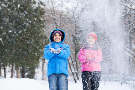 男孩和女孩向空中扔雪。
