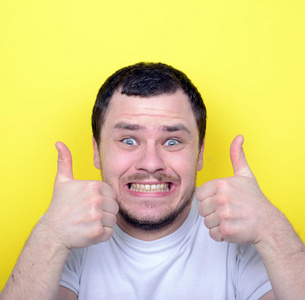 一幅表情滑稽的肖像画,举着大拇指对着喊叫照片